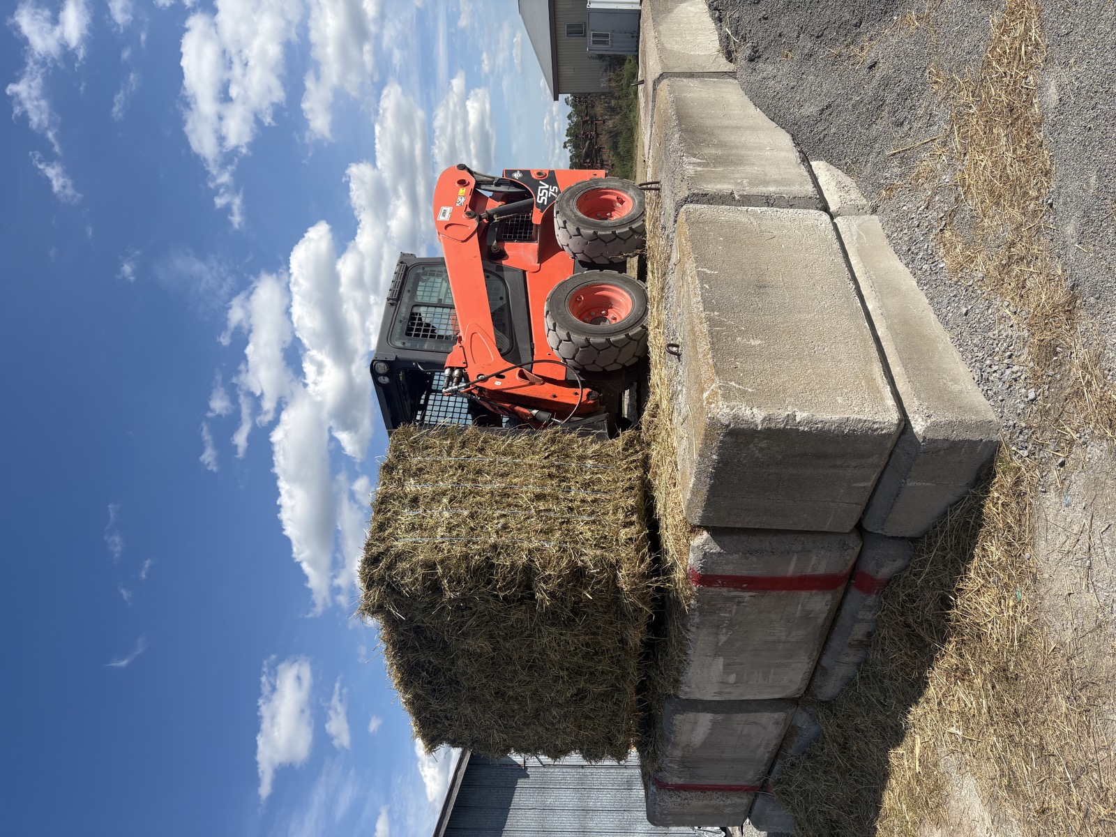 Skid steer handling hay at the HAY 365 operation