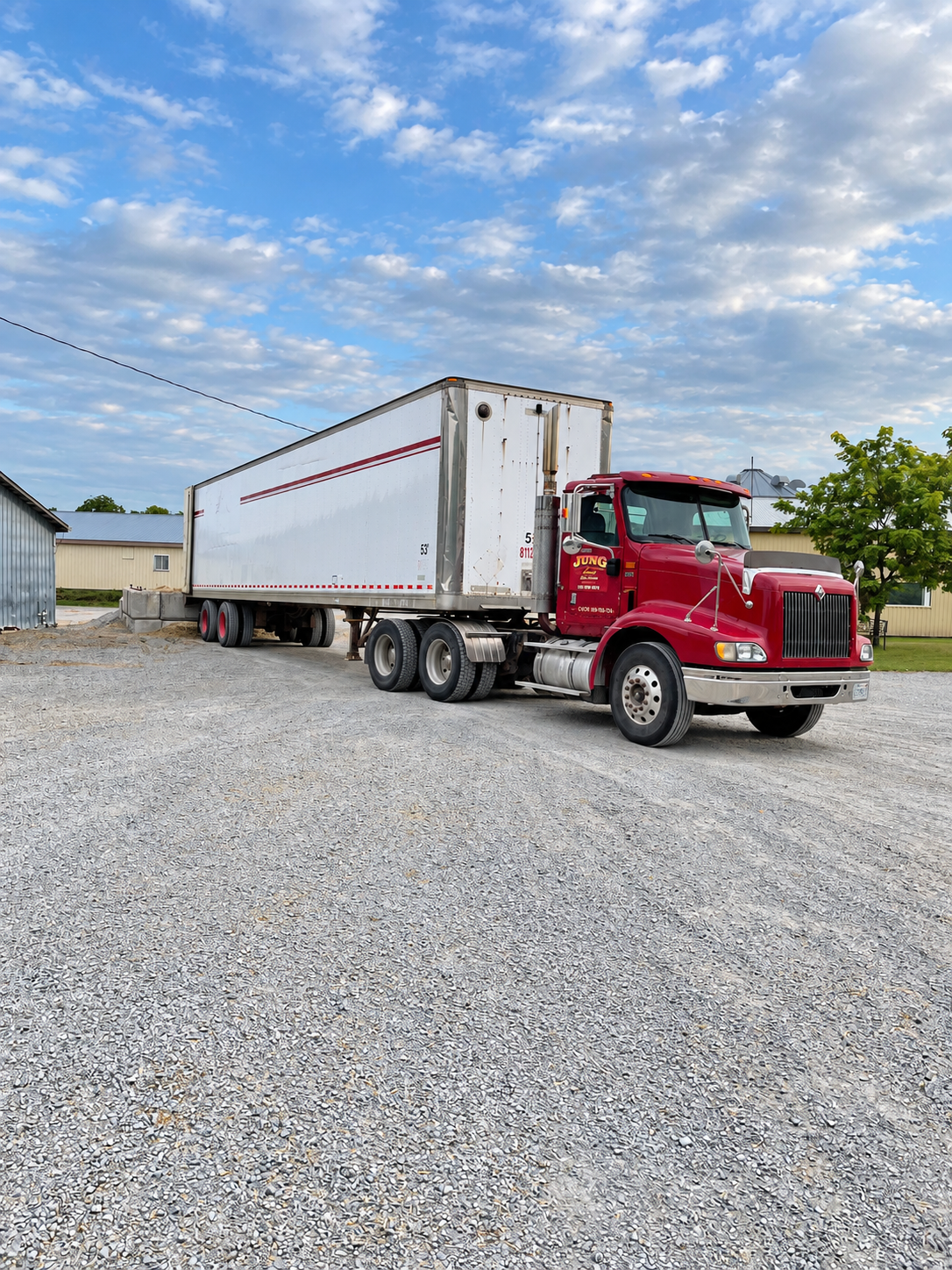 Red transport truck with a dry van trailer at HAY 365